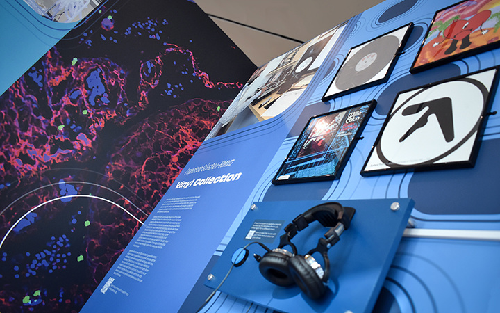 An exhibit panel a display of record covers and a listening station with headphones