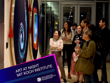 a group of people gathered around a large scientific image