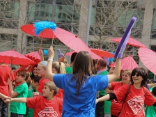 people waving umbrellas, pompoms, and foam fingers